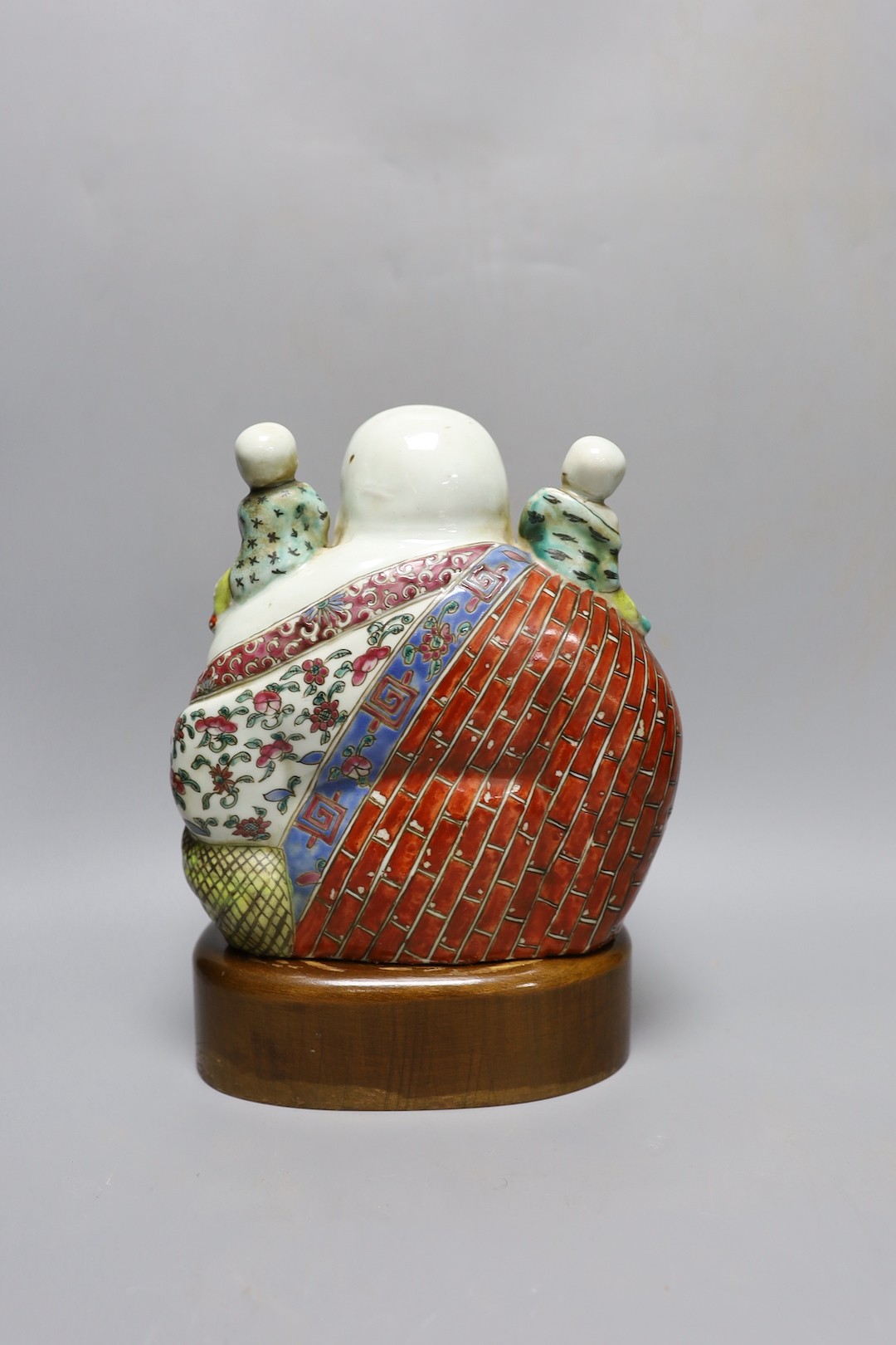 A Chinese enamelled porcelain Budai group, Republic period, on stand 25cm